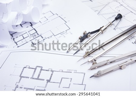 Architectural project, blueprints, blueprint rolls and divider compass, calipers on plans Engineering tools view from the top. Copy space. Construction background.