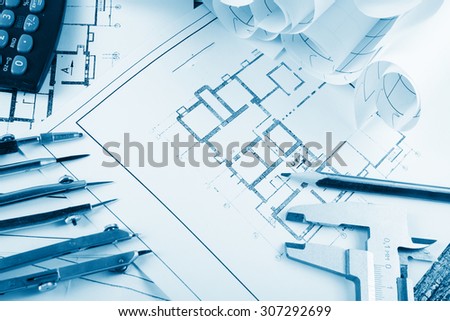 Architectural project, blueprints, blueprint rolls on plans. Engineering tools view from the top. Copy space. Construction background. Blue toned