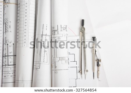 Workplace of architect - Architectural project, blueprints, blueprint rolls and divider compass on plans. Engineering tools view from the top. Construction background.