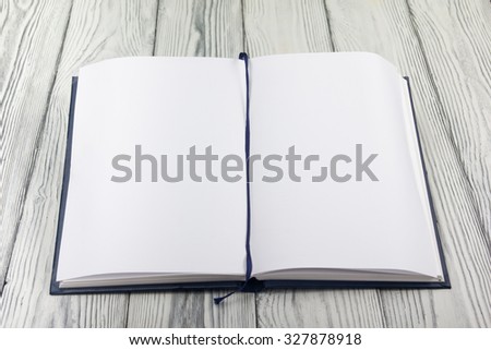 Open book with blank sheet of paper on wooden table. Back to school. Copy space