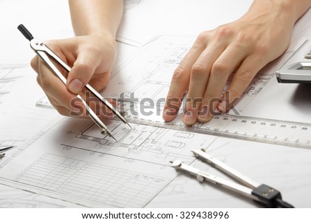 Architect working on blueprint. Architects workplace - architectural project, blueprints, ruler, calculator and divider compass. Construction concept. Engineering tools