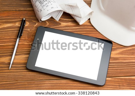 Workplace of architect - Architectural project, plan, blueprint rolls and blank tablet pc, pen, safety helmet on blank sheet of paper. Civil Engineering or Construction background. Copy space for text