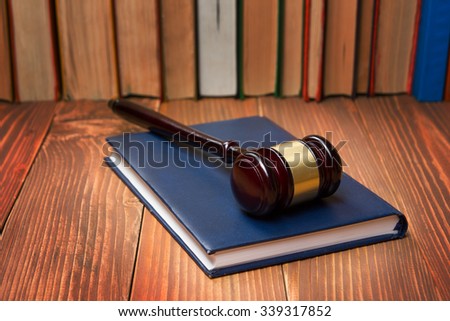Law concept - Law book with a wooden judges gavel on table in a courtroom or law enforcement office.