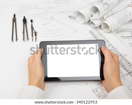 Architect working on blueprint. Architects workplace - architectural project, blueprints, tablet pc, divider compass. Construction concept. Engineering tools. Copy space for text.