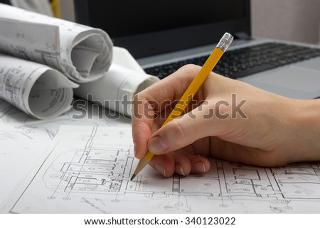 Architect working on blueprint. Architects workplace - architectural project, blueprints, laptop and divider compass, pencil. Construction concept. Engineering tools