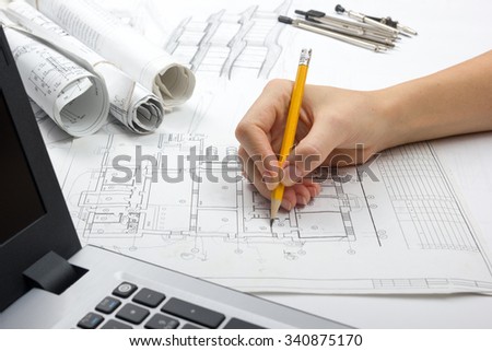 Architect working on blueprint. Architects workplace - Architectural project, blueprints, drawings, sketch, plan, laptop, pencil. Construction concept. Engineering tools