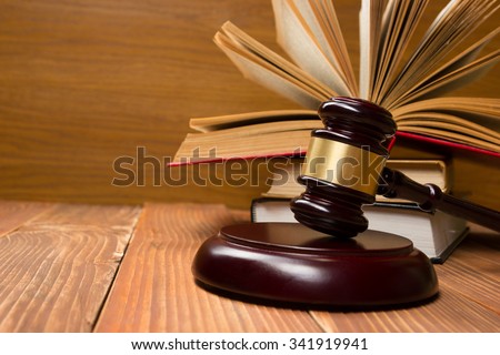 Law concept - Open law book with a wooden judges gavel on table in a courtroom or law enforcement office. Copy space for text