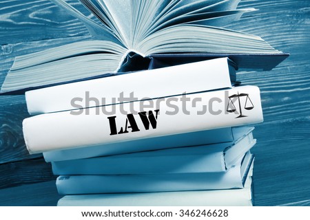 Law concept - Law book with Law word on table in a courtroom or law enforcement office. Toned image