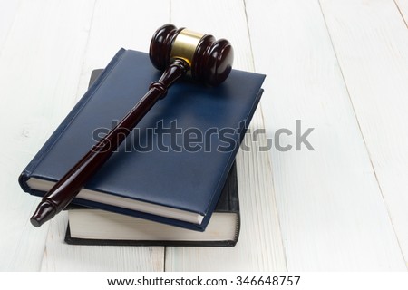 Law concept - Law book with a wooden judges gavel on table in a courtroom or law enforcement office.