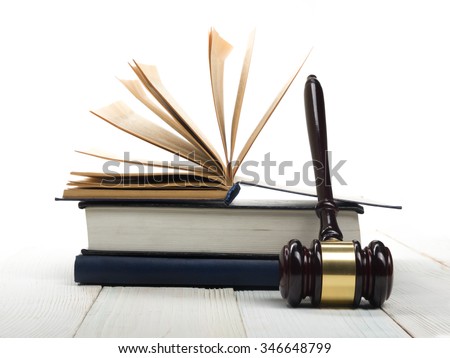 Law concept - Law book with a wooden judges gavel on table in a courtroom or law enforcement office isolated on white background. Copy space for text.