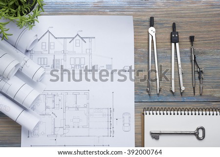 Real Estate concept. Architectural project, blueprints, blueprint rolls and  divider compass on vintage wooden table. Top view. Construction background. Engineering tools. Architect workplace.