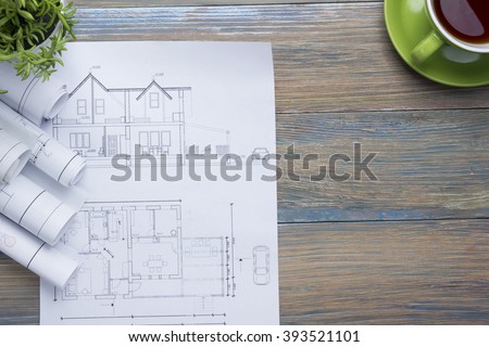 Architect worplace top view. Architectural project, blueprints, blueprint rolls and  divider compass, calipers on vintage wooden desk table. Construction background. Engineering tools. Copy space