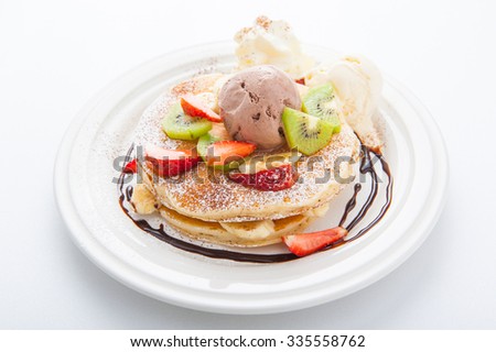 The Original pancakes with banana,ice cream and whipped cream on white dish