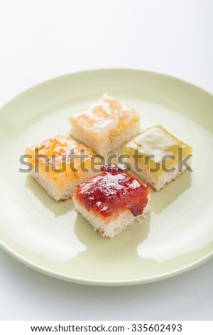Mix fruit, blueberry, orange fruit jam spread on bread toast over white background