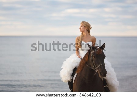 Bride on a horse by the sea in their wedding day