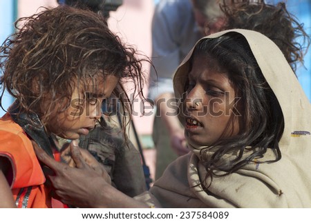 VARANASI, INDIA - MARCH 25, 2007: Unidentified pilgrim woman takes care about kid on March 25, 2007 in Varanasi, India. Varanasi is one the holiest of the seven sacred cities in Hinduism.