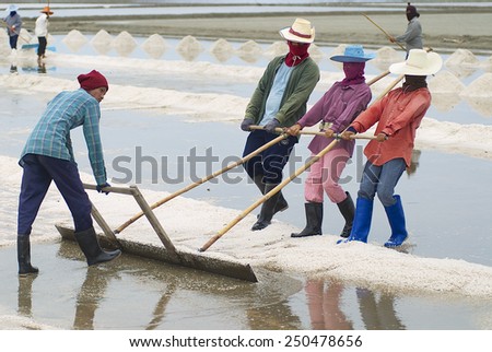 HUAHIN, THAILAND - MAY 13, 2008: Unidentified people work at the salt farm on May 13, 2008 in Huahin, Thailand. Salt production is one of the important industries in Huahin area.