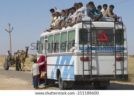 JAMBA, INDIA - APRIL 02, 2007: Unidentified people enter the bus on April 02, 2007 in Jamba, India. Public transportation buses in the Great Thar desert, Rajasthan is usually overloaded.
