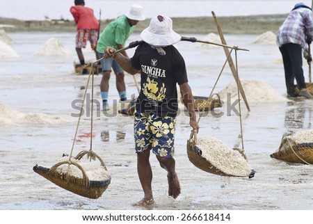 HUAHIN, THAILAND - MAY 13, 2008: Unidentified people work at the salt farm in Huahin, Thailand. Salt production is one of the main industries in Huahin area.