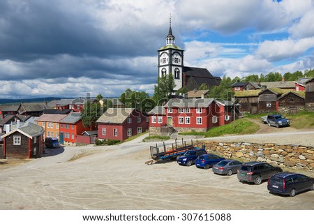 ROROS, NORWAY - JUNE 24, 2013: View to the traditional wooden houses and church bell tower of the copper mines town of Roros in Roros, Norway. Roros is declared a UNESCO World Heritage site.