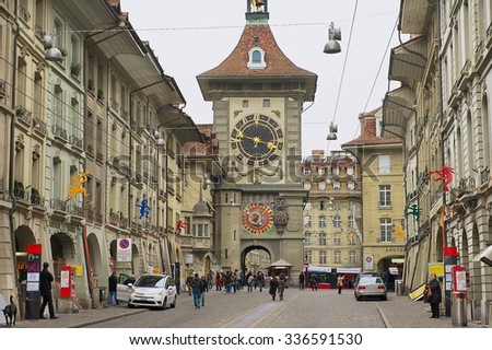 BERN, SWITZERLAND - FEBRUARY 23, 2012: Unidentified people walk by the street with the historic Bern Clock tower at the background in Bern, Switzerland.