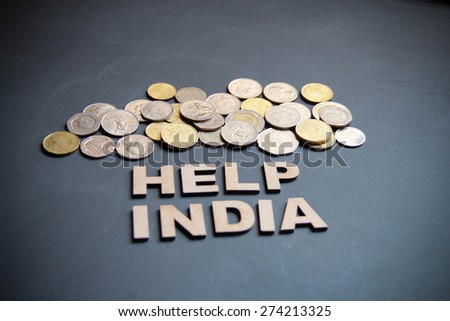 Help India with money is the concept here on blackboard. Wooden letters are here with different countries currencies.