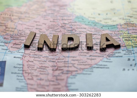 Global map of papers with India written by wooden alphabet