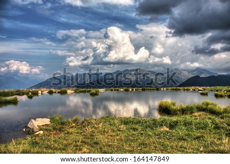 Alpine lake. An HDR picture of a small lake in a high pasture, Italian Alps.