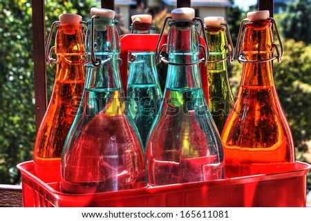 Six colorful water bottles in a cassette. HDR picture.