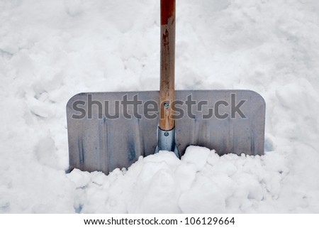 Close up of aluminum snow shovel in deep snow