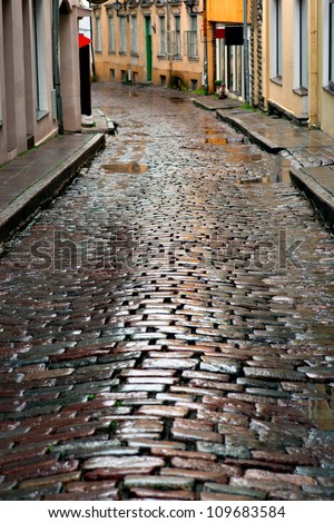 Wet cobblestones after rain on narrow street in the old town of Tallinn, Estonia