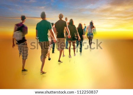 Bunch of young people walking towards sunrise