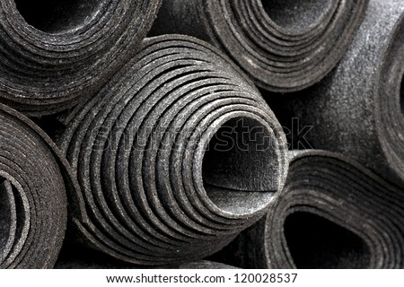 background with rolls of black foam used for insulation