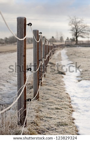 Electric fence with rime frost in rural area