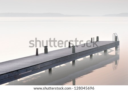Sparse image of jetty in foggy lake