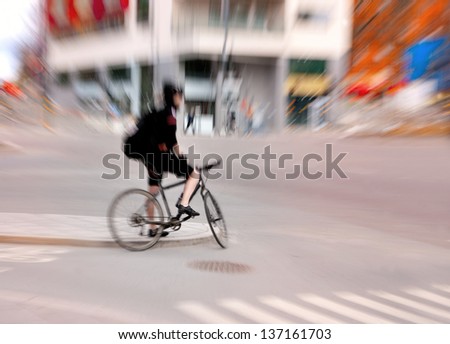 Blurred cyclist waiting for green light  in city