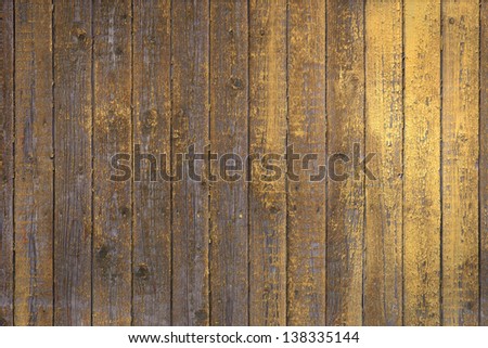 Background of flaking old knotted yellow wooden wall