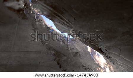 low angle view of ice world with icicles and sky seen through a gap