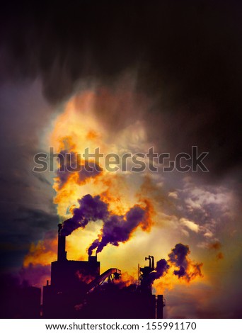 Factory with chimneys emitting smoke on blue sky