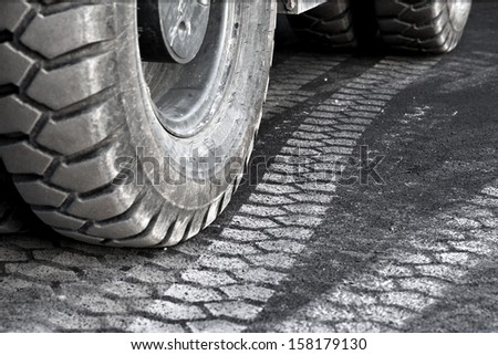close up of truck wheel and tire print on asphalt