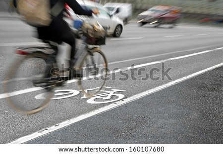 Female cyclist in bicycle lane on busy street