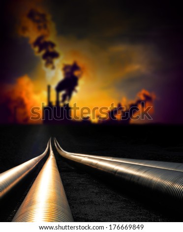 Pipelines in sunset with smoking factory in background