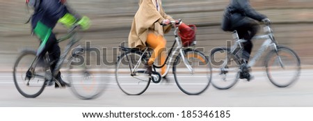Three cyclists at high speed in blurred motion