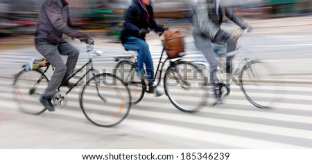 Three cyclists at high speed in blurred motion in city