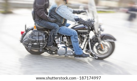 Two persons on motorbike in blurred motion