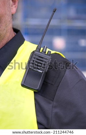 walkie-talkie on sholder of man i yellow vest