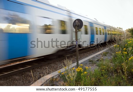 Commuter train at full speed in a rural area