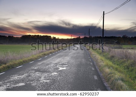Sunset over a narrow country road in early autumn