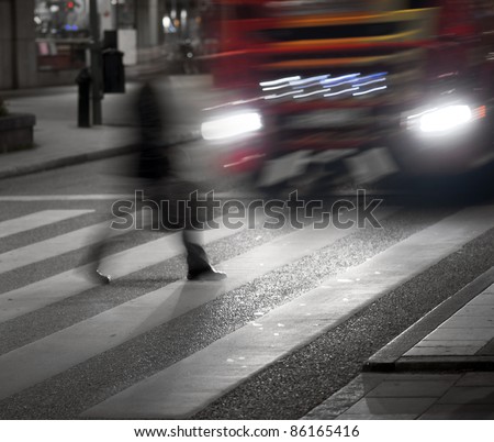 Man crossing street in front of big vehicle