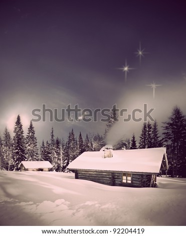 Remote log cabin in winter evening with stars in sky